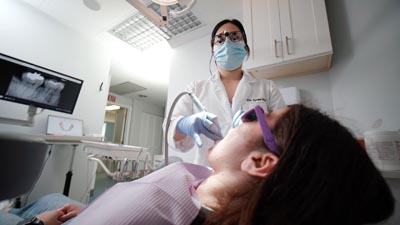 Dr. Shin cleaning a patient's teeth at U Shine Dental, located in Alexandria, VA