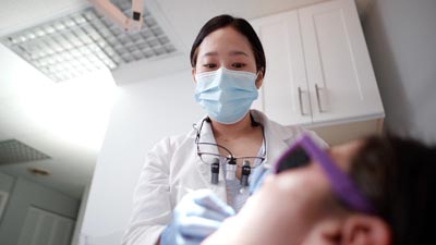 Dr. Shin providing preventive dental care for a patient at U Shine Dental in Alexandria, VA