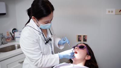 Dr. Shin providing dental care for a patient at U Shine Dental, located in Alexandria, VA