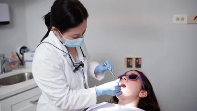 Dr. Shin providing dental care for a patient at U Shine Dental, located in Alexandria, VA